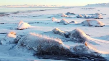 Winter Iceland Landscape at Sunrise. Unusual Snow Covered Hills On The Ocean Shore. Beautiful Abstract Aerial View. Popular Tourist Destination. Travel Europe. 4k. High quality 4k footage