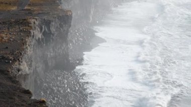 İzlanda 'daki okyanus kıyıları, volkanik dağlar, dev dalgalı siyah kumsallar. İzlanda 'nın ünlü turistik merkezi. Dyrholaey, Vik. 8K çözünürlükte 4320 peni. Yüksek kalite 4k görüntü