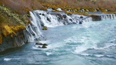 Autumn Waterfall in Iceland. Pure Turquoise Water in Mountain River. Popular Tourist Spot. Famous Travel Destination. Beautiful Nature, Unusual Landscape. Footage Shot in 8K Resolution 4320p.