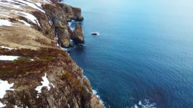 Günbatımında Kayalık Kıyı şeridi üzerinde Mavi Kuzey Atlantik Okyanusu Suyu ile birlikte Güneş 'e doğru uçuyor. Kuş Gözü Görünümü 4K Sinematik İnsansız Hava Aracı. Yüksek kalite 4k görüntü