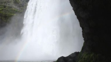 İzlanda 'da Skogafoss şelalesi, uçurumlardan akan su, ünlü cazibe. Kocaman bir dağ nehri. Doğa ilkbahar manzarası. 8K çözünürlükte 4320 peni. Yüksek kalite 4k görüntü