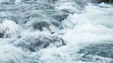 Taş kayaların arasından akan saf su akıntısı. Yaz Günü 'nde Vahşi Dağ Nehri Suyun Sıçrıyor. İzlanda. 8K 'da çekilmiş..