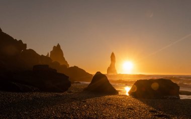 Black Sand Beach In Iceland. Sunset over Volcanic Cliffside. Stunning Ocean Coast. Unusual Pure Nature. Famous Tourist Location near Vik. Traveling in Iceland. Shot in High Resolution.