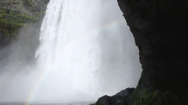 İzlanda 'da Skogafoss şelalesi, uçurumlardan akan su, ünlü cazibe. Kocaman bir dağ nehri. Doğa ilkbahar manzarası. 8K çözünürlükte 4320 peni. Yüksek kalite 4k görüntü