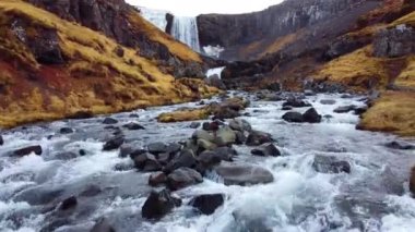 İzlanda 'da büyük manzaralı bir şelale. Dağlardaki saf buzul nehri. Sonbahar renkleri hava görüntüsü 4K. Yüksek kalite 4k görüntü