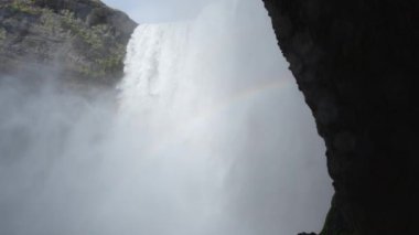 İzlanda 'da Skogafoss şelalesi, uçurumlardan akan su, ünlü cazibe. Kocaman bir dağ nehri. Doğa ilkbahar manzarası. 8K çözünürlükte 4320 peni. Yüksek kalite 4k görüntü