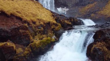 İzlanda 'da büyük manzaralı bir şelale. Dağlardaki saf buzul nehri. Sonbahar renkleri hava görüntüsü 4K. Yüksek kalite 4k görüntü
