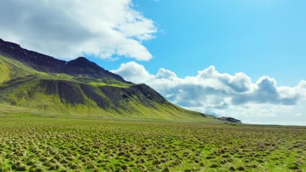 冰岛的风景 春天有绿草的山 云彩笼罩群山 一个平静而阳光灿烂的日子的背景 空中俯瞰乡村风景 — 图库视频影像
