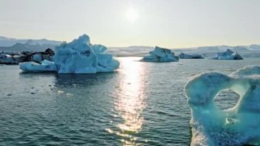 İzlanda Turkuaz Buzul Gölü 'nde Büyük Buz Parçaları Gün Batımında eriyen bir buzuldan oluşan açık mavi buzdağları Şafakta Arktik Manzarası Epic Aerial View. Yüksek kalite 4k görüntü