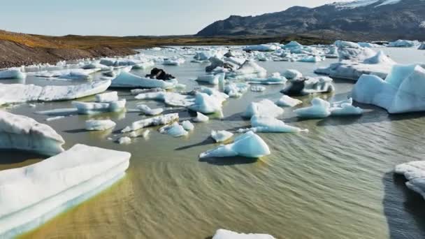 冰岛全球暖化中的布朗冰川湖中的大块浮冰与从融化的冰川形成的清晰的蓝色冰山在黎明4K处的空中景观 — 图库视频影像