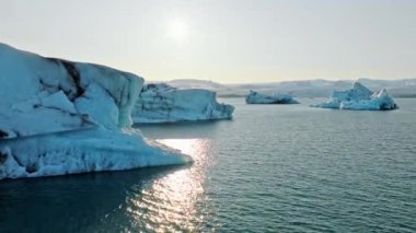 İzlanda Turkuaz Buzul Gölü 'nde Büyük Buz Parçaları Gün Batımında eriyen bir buzuldan oluşan açık mavi buzdağları Şafakta Arktik Manzarası Epic Aerial View. Yüksek kalite 4k görüntü