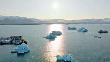 İzlanda Turkuaz Buzul Gölü 'nde Büyük Buz Parçaları Gün Batımında eriyen bir buzuldan oluşan açık mavi buzdağları Şafakta Arktik Manzarası Epic Aerial View. Yüksek kalite 4k görüntü