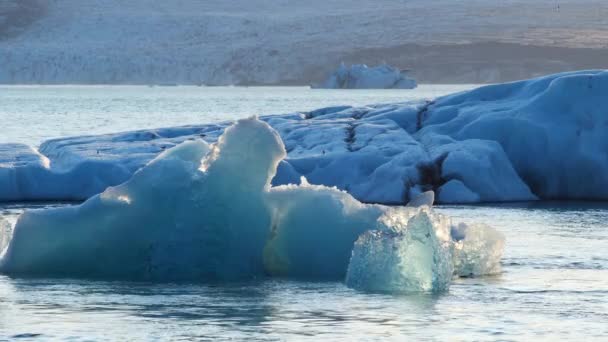 蓝冰山与冰河清澈自然的分离冰河清澈的蓝冰漂流盐水绿松石冰舱中受欢迎的旅游胜地乔库沙隆冰川湖 — 图库视频影像