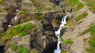 Dağlık bölgelerde şelale, kanyonun içindeki dağ nehri, destansı hava aracı görüntüsü. Yaz mevsiminde İzlanda. Yüksek kalite 4k görüntü