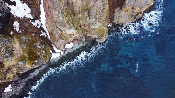 바위가 해안선을 아이슬란드의 봄철에는 대서양의 바닷물 눈으로 뒤덮여 공중에서 — 비디오