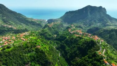 Küçük bir kasabanın üstündeki havadan, yaz aylarında sahildeki Village at Mountain 'dan. Madeira, Portekiz. Yüksek kalite 4k görüntü