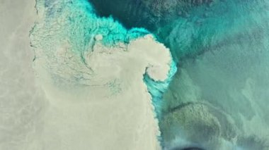 İzlanda 'da iki nehir birbirine karışır, saf buzul turkuvaz suyu çamurlu suyla karışır, hayal edilemeyen bir manzara ve nehirde soyut desenler bulunur. 4k