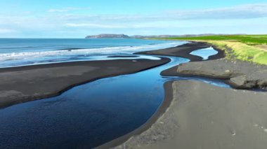 River Flows into the Ocean on a Beautiful Coast in İzlanda, Peyzaj with Black Volcanic Sand in Summer Season. Yüksek kalite 4k görüntü