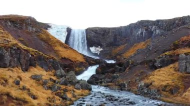 İzlanda 'da büyük manzaralı bir şelale. Dağlardaki saf buzul nehri. Sonbahar renkleri hava görüntüsü 4K. Yüksek kalite 4k görüntü