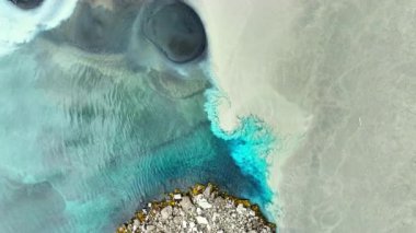 Saf buzul türkuaz su çamurlu suyla karışır, İzlanda 'da iki nehir karışır, hayal edilemez manzara ve nehirde soyut desenler bulunur. 4k