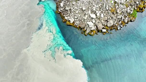 清澈的冰川绿松石水与浑浊的水混合在一起 两条河流在冰岛混合在一起 难以想像的风景与抽象的河流模式 — 图库视频影像
