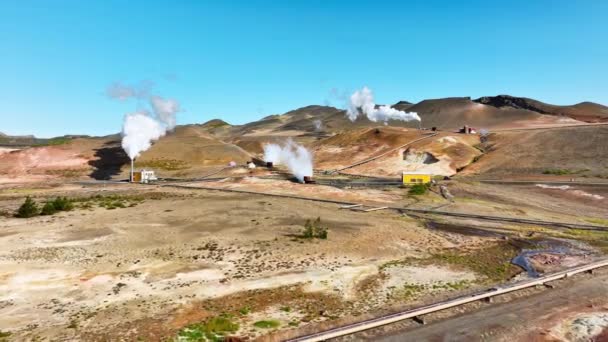 アイスランドの絵のように美しい火山の風景に位置する現代の地熱発電所ホットホワイト蒸気煙は パイプ再生可能エネルギー空中ビューから来ています 高品質4K — ストック動画