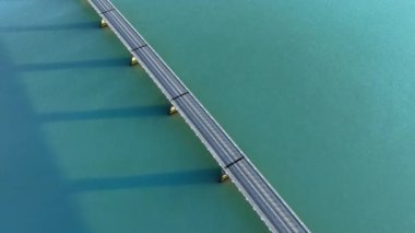 Turkuaz deniz suyu üzerinde köprü, şehir altyapısı, arabalar için yol. İzlanda 'daki güzel soyut manzara. Yüksek kalite 4k görüntü
