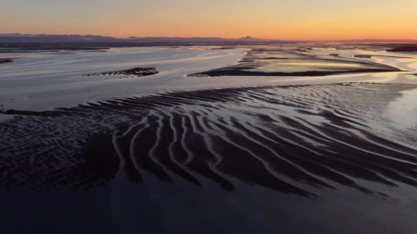 低潮时 冰岛峡湾上空的日出 风景海洋海岸线 太阳风暴中具有奇异模式的黑色火山灰 高质量的4K镜头 — 图库视频影像