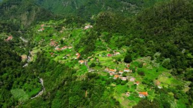 Küçük bir kasabanın üstündeki havadan, yaz aylarında sahildeki Village at Mountain 'dan. Madeira, Portekiz. Yüksek kalite 4k görüntü