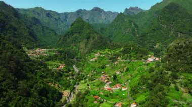 Küçük bir kasabanın üstündeki havadan, yaz aylarında sahildeki Village at Mountain 'dan. Madeira, Portekiz. Yüksek kalite 4k görüntü
