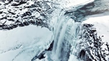 Kışın donmuş şelale, kar ve buzun büyülü bir yeri, büyük bir akıntısı olan saf buzul suyu. Yüksek kalite 4k görüntü