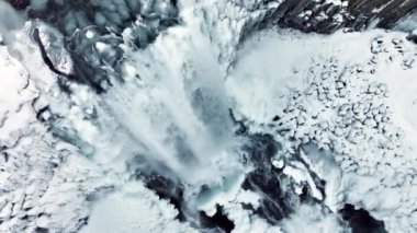 Kışın donmuş şelale, kar ve buzun büyülü bir yeri, büyük bir akıntısı olan saf buzul suyu. Yüksek kalite 4k görüntü