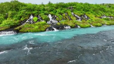 Birçok küçük şelalesi olan mavi buzul nehri, çarpıcı kuş bakışı manzaralı soğuk turkuaz buzul nehri yaz mevsiminde birçok deresi olan İzlanda, Hraunfossar ve Barnafoss. 4k 