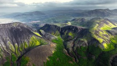 İzlanda dağlarında yosunlarla kaplı güzel siyah volkanik dağlar, sıra dışı doğa manzarası, muhteşem kuşların bakış açısı, insansız hava aracının destansı görüntüsü. 4k