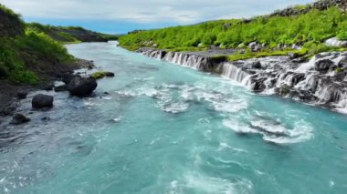 Birçok küçük şelalesi olan mavi buzul nehri, çarpıcı kuş bakışı manzaralı soğuk turkuaz buzul nehri yaz mevsiminde birçok deresi olan İzlanda, Hraunfossar ve Barnafoss. 4k 