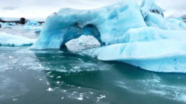 Okyanusta buzdağı, dalgalarda yüzen dev mavi buzullar, İzlanda 'da kutup doğası. Yüksek kalite 4k görüntü