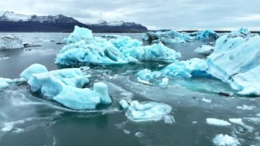 Okyanusta buzdağı, dalgalarda yüzen dev mavi buzullar, İzlanda 'da kutup doğası. Yüksek kalite 4k görüntü
