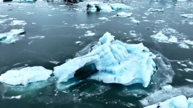 Okyanusta buzdağı, dalgalarda yüzen dev mavi buzullar, İzlanda 'da kutup doğası. Yüksek kalite 4k görüntü