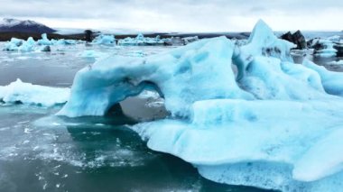Okyanusta buzdağı, dalgalarda yüzen dev mavi buzullar, İzlanda 'da kutup doğası. Yüksek kalite 4k görüntü