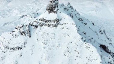 Dik tepeler buz ve karla kaplıdır ve vadiler bulutlar ve sisle örtülüdür. Yüksek kalite 4k görüntü