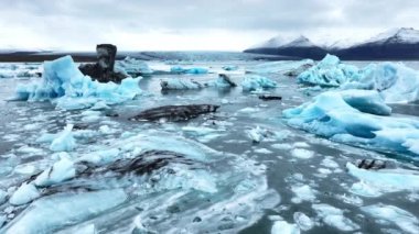 Okyanusta buzdağı, dalgalarda yüzen dev mavi buzullar, İzlanda 'da kutup doğası. Yüksek kalite 4k görüntü