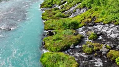 Birçok küçük şelalesi olan mavi buzul nehri, çarpıcı kuş bakışı manzaralı soğuk turkuaz buzul nehri yaz mevsiminde birçok deresi olan İzlanda, Hraunfossar ve Barnafoss. 4k 