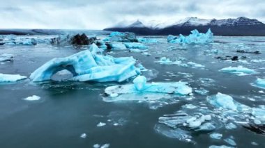 Okyanusta buzdağı, dalgalarda yüzen dev mavi buzullar, İzlanda 'da kutup doğası. Yüksek kalite 4k görüntü
