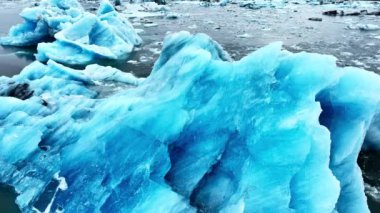 Okyanusta buzdağı, dalgalarda yüzen dev mavi buzullar, İzlanda 'da kutup doğası. Yüksek kalite 4k görüntü