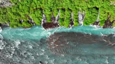 Birçok küçük şelalesi olan mavi buzul nehri, çarpıcı kuş bakışı manzaralı soğuk turkuaz buzul nehri yaz mevsiminde birçok deresi olan İzlanda, Hraunfossar ve Barnafoss. 4k 