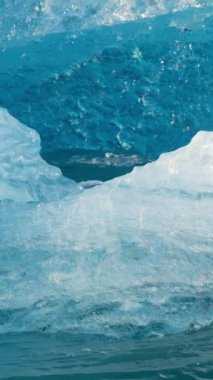 Kuzey Kutbu 'nda saf mavi buz. Buzdağları İzlanda 'daki buzuldan ayrılır. Kristal berrak mavi buz tuzlu turkuaz suda yüzer. Sosyal medya için çekim. Jokulsarlon Buzul Gölü. 