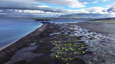 İzlanda 'da benzersiz siyah kumlu sahil. Yeşil küçük tepeleri olan eşsiz kıyı şeridi. 4k' lik olağanüstü soyut manzarası var.