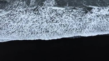 Kara kum volkanik plajı, çarpan dalgalar, dingin ve sakin bir manzara. İzlanda 'nın ünlü simgesi. Yüksek kalite 4k görüntü