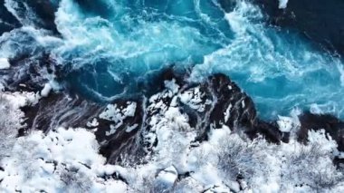 Saf turkuaz su, dev bir akıntısı olan buzul nehri İzlanda 'da şelale, kışın donmuş şelale, kar ve buzun büyülü kış mekanı, popüler turizm merkezi.