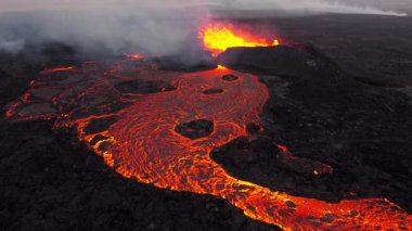 Volkan patlaması, İzlanda 'da yerden kızgın lav püskürmesi, insansız hava aracı magma nehrinin üzerinde uçması. Litli Hrutur Patlaması 2023. Yüksek kalite 4k görüntü